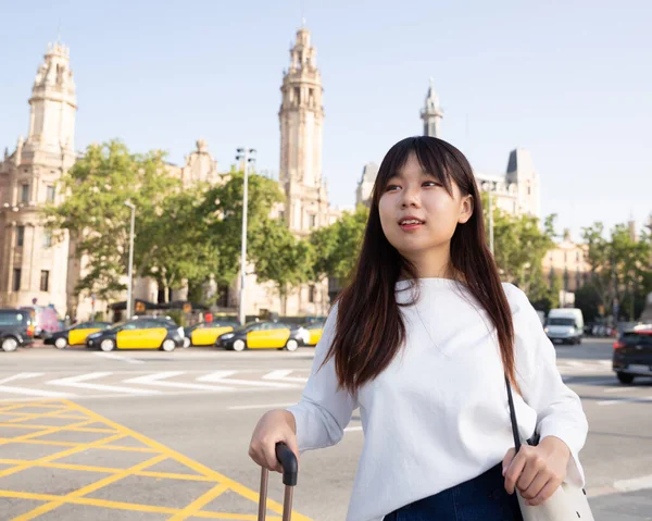 Sonriente joven turista china chica dando un paseo por la ciudad con una bolsa de viaje — Foto de Stock