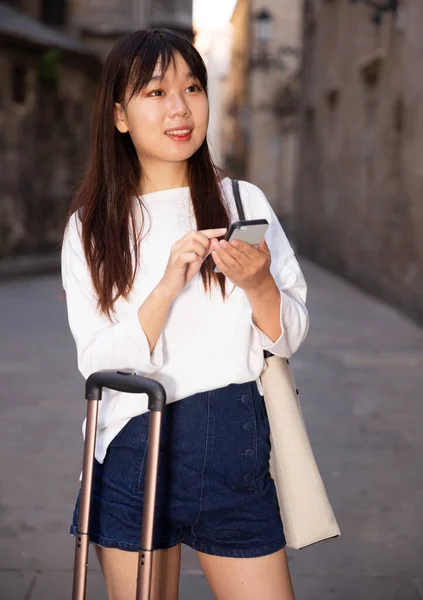 Young chinese female is looking up the way in phone by using gps — Stock Photo, Image