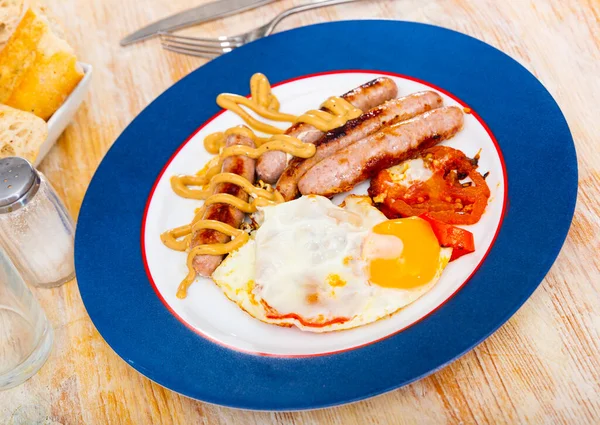 Fried eggs with tomatoes, sausages and mustard — Stock Photo, Image