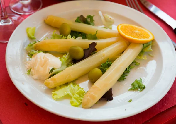 伝統的なヨーロッパのベジタリアン料理の焼き白アスパラガスのガーリックソース オレンジのスライス 緑とオリーブ — ストック写真