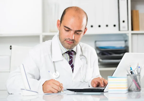 Man arbetar i läkarmottagningen på laptop — Stockfoto