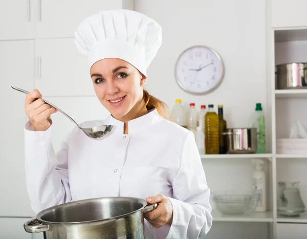 Vrouwelijke kok proeverij voedsel — Stockfoto