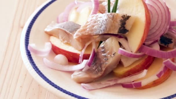 Σαλάτα ρέγγας με μήλα και κρεμμύδια γαρνιρισμένη με κρεμμυδάκια. Νορβηγική κουζίνα — Αρχείο Βίντεο