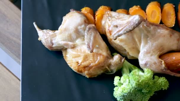 Teriyaki de codorna com cenouras grelhadas fatiadas e brócolis em placa de serviço preta — Vídeo de Stock
