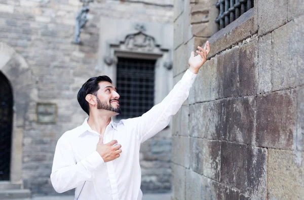 Man in de buurt van stenen muur zingende serenade — Stockfoto