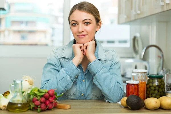 Sorrindo dona de casa sentado na cozinha — Fotografia de Stock