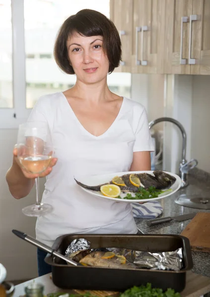 Vrouw met dorado vis in bakplaat — Stockfoto