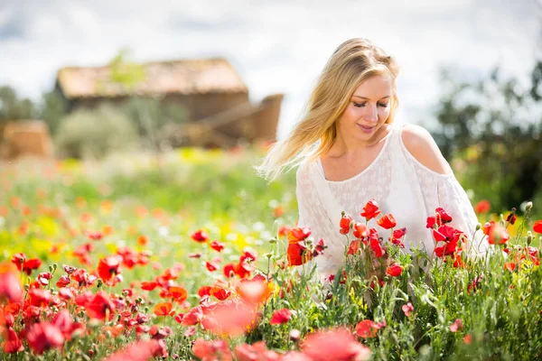 Gyönyörű fiatal nő fehér ruhában a mák mező vad virágok — Stock Fotó