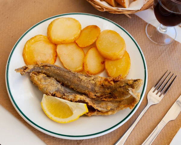 Fried hake served with boiled potatoes and lemon — Stock Photo, Image