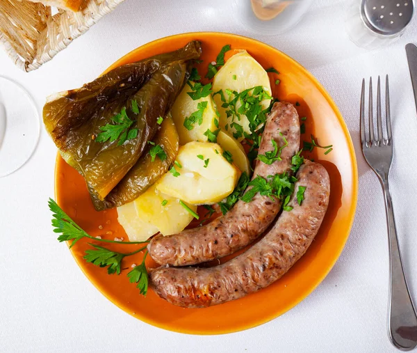 Tasty fried pork sausages with baked potatoes and pepper — Stock Photo, Image