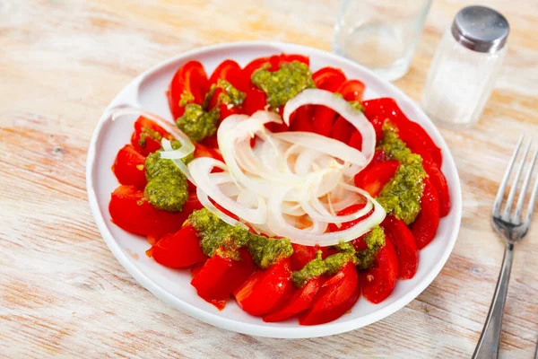 Frische Tomaten mit grüner Pesto-Sauce und Zwiebeln — Stockfoto
