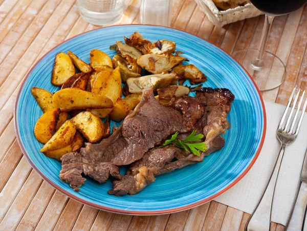 Delicious beef steak with baked potatoes and artichokes — Stock Photo, Image