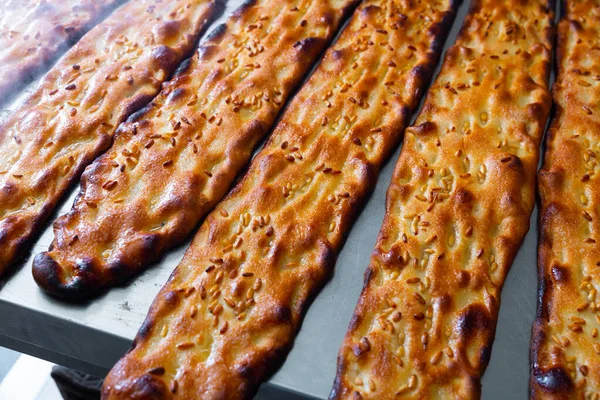 Primo piano di cocco appena sfornato con semi di sesamo in panetteria — Foto Stock