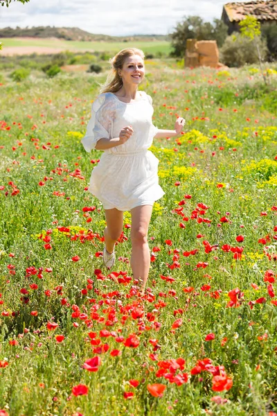 Fine woman running in field with poppies plants — Stock Photo, Image