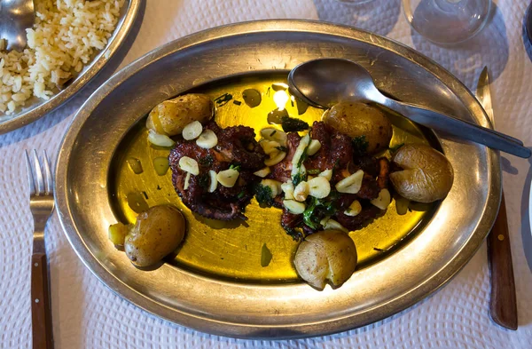 Poulpe rôtie savoureuse à plat avec pommes de terre cuites au four et ail — Photo