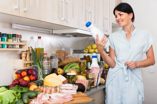 Portrait of woman who is holding cheese and milk that she buyed in market. — Stock Photo, Image