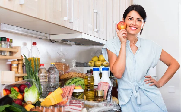 Retrato de mulher alegre com maçã na cozinha em casa. — Fotografia de Stock