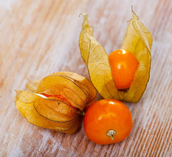 Orangefarbene Physalis-Früchte auf Holztisch — Stockfoto