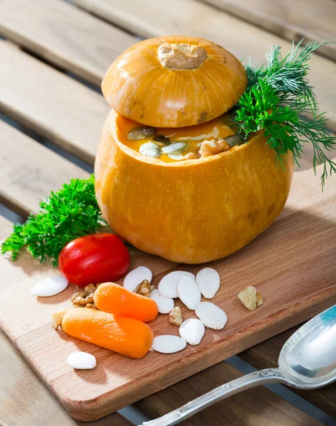Cooked homemade vegetable pumpkin cream soup in pumpkin — Stock Photo, Image
