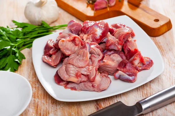 Surowe żołądki i warzywa z kurczaka na powierzchni drewnianej — Zdjęcie stockowe