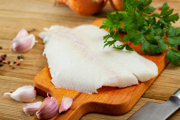 Filete de pescado crudo de fletán antes de cocinar sobre fondo de madera —  Fotos de Stock