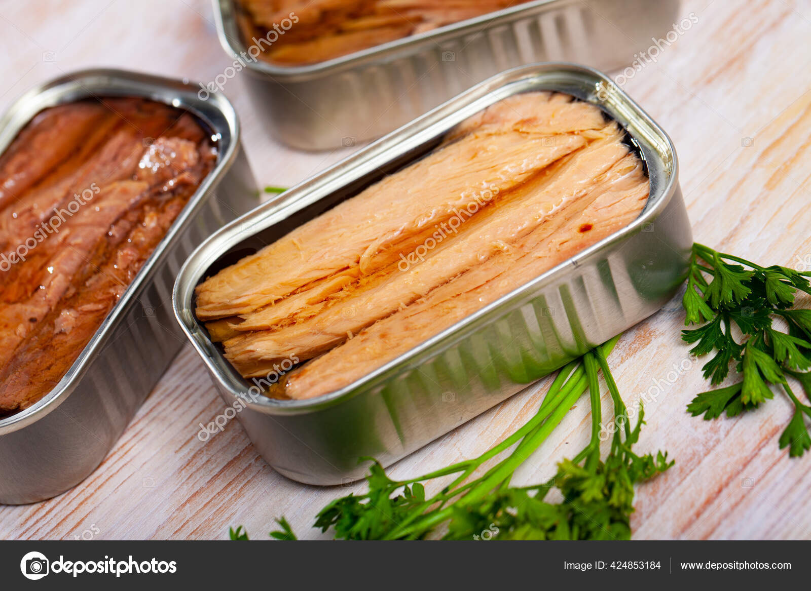 Natural frigate mackerel fillets and parsley can on wooden table Stock