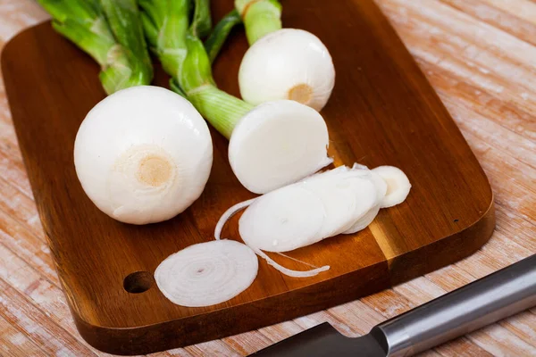 Delicate white onion with tops closeup on table — Stock Photo, Image