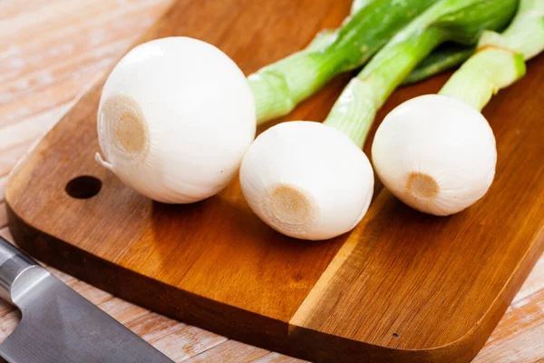 Cipolla di primavera su tavola di legno, preparazione alimentare — Foto Stock