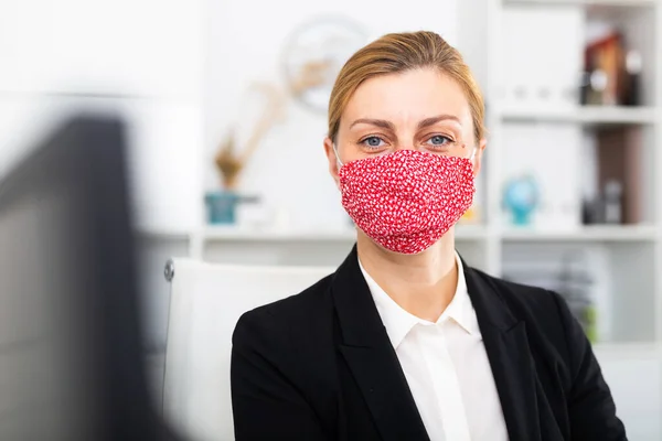 Kvinna manager i medicinsk mask på kontoret under arbetsdagen — Stockfoto