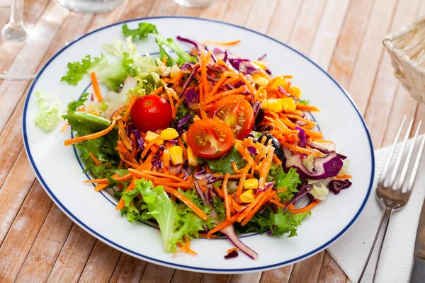 Teller mit köstlichem Salat aus Salat, Tomaten, Mais, Zwiebeln — Stockfoto