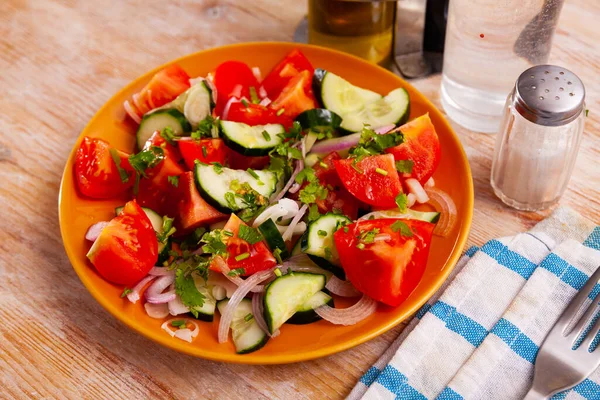 Heerlijke zomersla van komkommers en tomaten op bord — Stockfoto