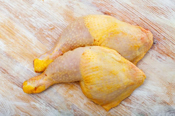 Cuartos de pierna de pollo crudo fresco en superficie de madera —  Fotos de Stock