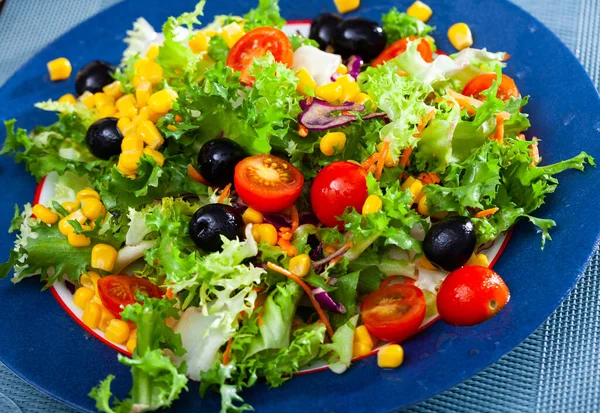 Placa de deliciosa ensalada hecha de lechuga, tomates, maíz, cebolla — Foto de Stock