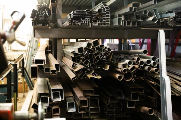 Perfil de metal do tubo encontra-se nas prateleiras da oficina — Fotografia de Stock