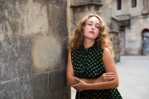 Mujer sexy joven en vestido de pie cerca de la pared de piedra en el centro histórico —  Fotos de Stock