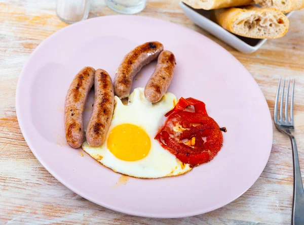 Huevos fritos con tomates y salchichas para el desayuno —  Fotos de Stock