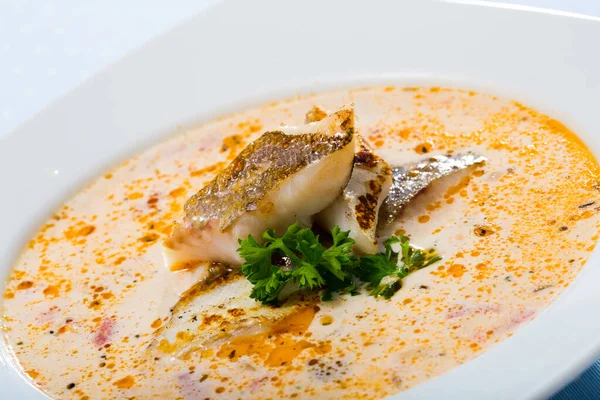 Sopa cremosa saborosa com bacalhau de peixe branco e verduras no prato branco — Fotografia de Stock