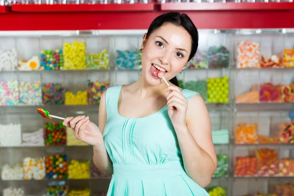 Sorrindo menina chupando pirulito na loja — Fotografia de Stock