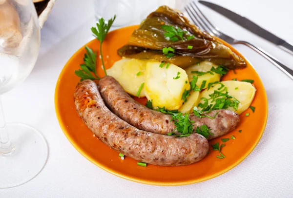 Saucisses maison frites avec pommes de terre cuites au four et poivre cuit — Photo