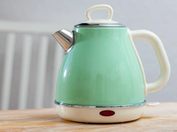 Metal light green electric kettle on wooden surface — Stock Photo, Image