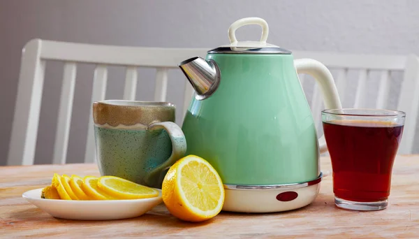 Dos tazas de té con hervidor eléctrico y rodajas de limón — Foto de Stock