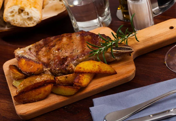 Beef steak with potatoes on a wooden board — Stock Photo, Image