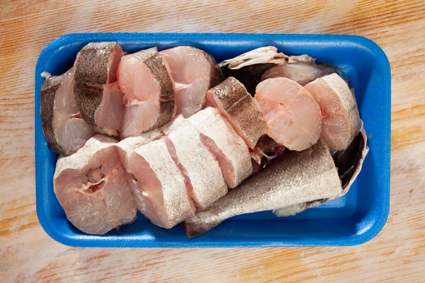 Raw steaks of whiting fish in blue plastic tray — Stock Photo, Image