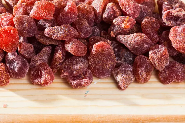 Tasty dried red strawberry berries on wooden surface — Stock Photo, Image