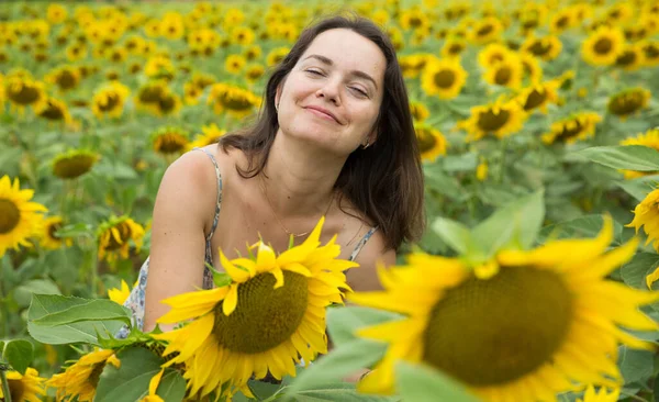 Meisje in zonnebloemen veld — Stockfoto