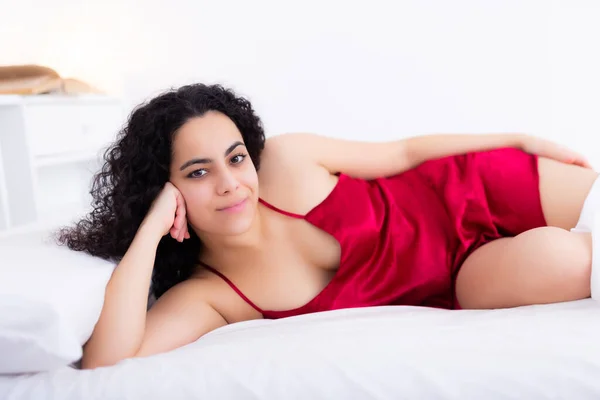 Vrouw in lingerie genieten liggend op bed — Stockfoto