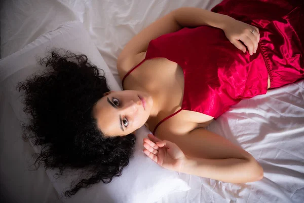 Mujer en lencería disfrutando acostada en la cama —  Fotos de Stock