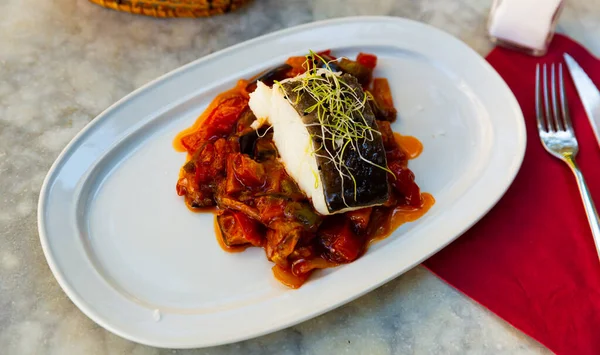 Küche spanischer kandierter Fisch mit gedünstetem Gemüse auf weißem Teller — Stockfoto