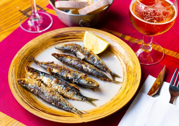 Deliciously fried many sardines served with lemon at plate — Stock Photo, Image