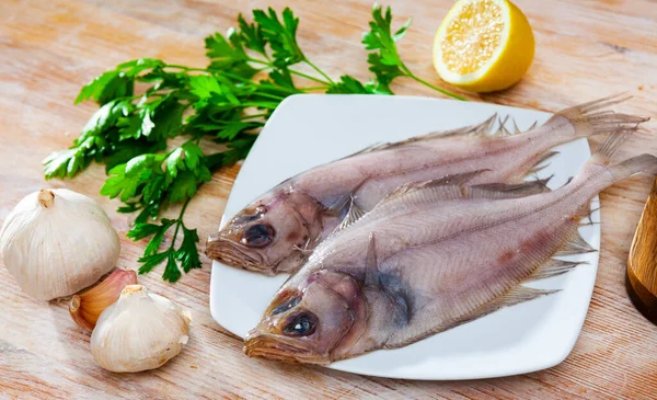 Uncooked flatfish fish with parsley and garlic — Stock Photo, Image